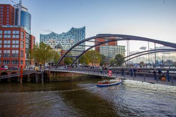 Original architecture of Hamburg - bridges and   buildings in  autumn . Touristic boat floating in canal