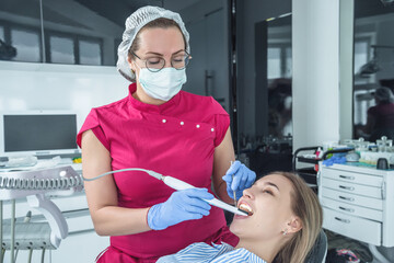 The dentist examines a patient at a reception in the dental office. The concept of health care and...