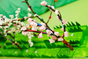 Spring theme. Boy making flowering apple tree garden layout. Recycling concept. Trees made of tree branch and styrofoam.