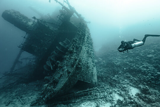 scuba diver in the sea exploring an old wreck 