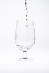 Pour water in glass isolated on white background.