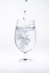 Pour water in glass isolated on white background.