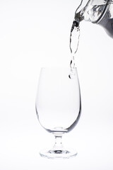 Pour water in glass isolated on white background.