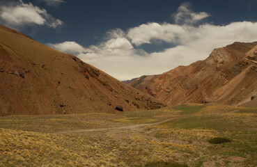 The arid mountains and valley. View of the yellow grassland and red hills in a sunny day.  