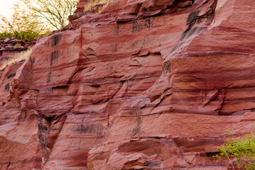 Sandstone forms when layers of sand accumulates by sedimentation are compacted & cemented by precipitation of minerals within pore spaces of sand grains. Red color is imparted by Hematite Iron oxide.