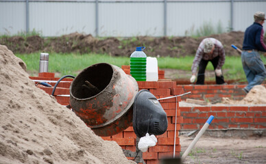 Electric concrete mixer on the background of building a house