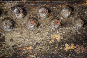 close up of an old rusty metal plate with rivets