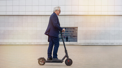 Senior businessman riding electric scooter in a cityscape       © D'Action Images