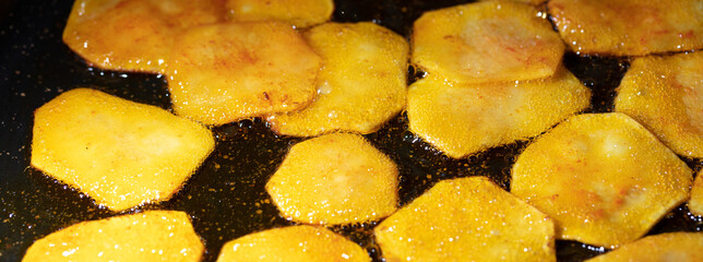 Potato chips are fried in oil