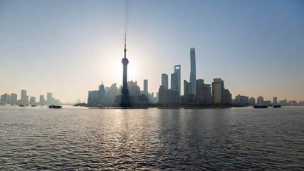 Sun rising behind the Oriental Pearl Tower. Pudong skyline at dusk.