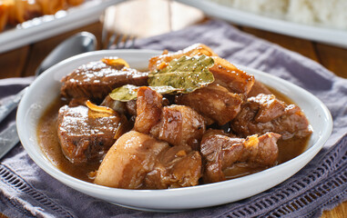 filipino pork adobo in bowl with bay leaves close up