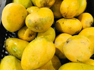 yellow mangoes on market stall