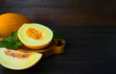 melon slices on a dark wooden background close-up. background with fresh melons on a wooden table. melons in a bowl.