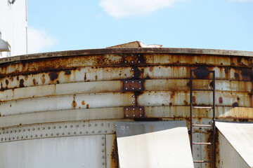 Fototapeta premium An old rusted silo photographed in a port area in summer