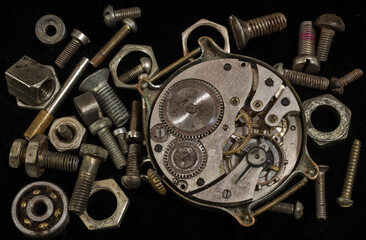 Watch mechanism among metal elements on black background close-up