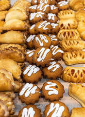 a lot of buns with different fillings and toppings are on the counter. High quality photo