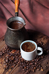 Coffee in cezve and white cup on a red background