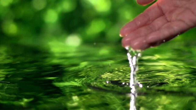 close up woman hand gently touches the surface of the water