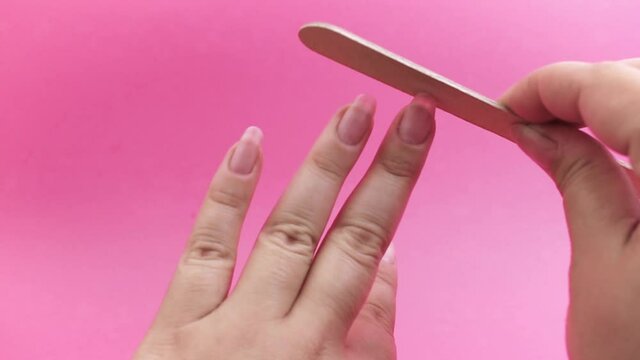The girl does a manicure. Woman hands doing manicure with nail file. Formation of nails.