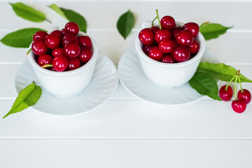 ripe cherries in white cups on a white background close-up. background with fresh cherry berries. cherry close-up.