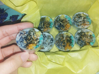 Homemade tea lights with crystals, dried herbs and flowers to attract money and good fortune,...