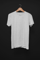 Grey T-Shirt on a hanger against a black background