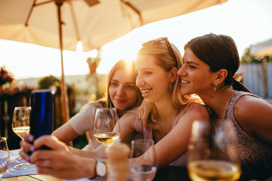 Three young woman at restaurant taking selfie