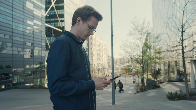 Young businessman on the phone in the financial district of downtown, new ways of financial growth in the digital modern age