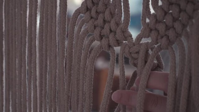 manos tejiendo nudos para un hermoso macram&eacute;