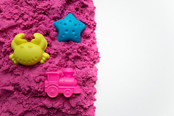 Top view pink kinetic sand with molds with copy space. Magic sand for children. Selective focus