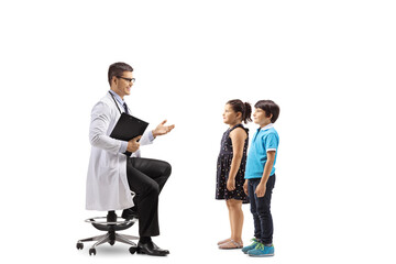 Male doctor sitting and talking to a little boy and girl