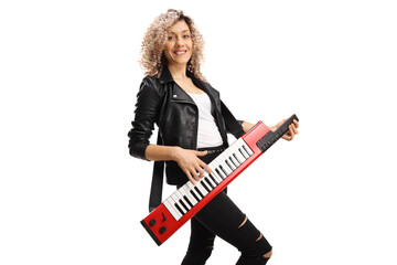 Fototapeta premium Female musician with a curly hair plaing on a red keytar