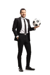 Full length portrait of a man in a black suit holding a football and smiling