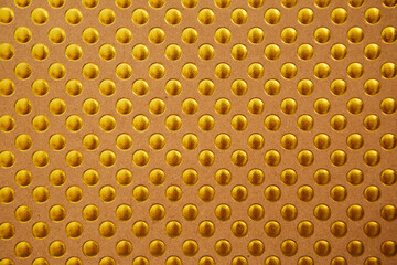 The background texture of a gold foil sheet wrapping paper with circles is brilliant for a Wallpaper decoration item or packaging.