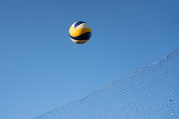 volleyball ball in the air over the net