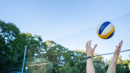 volleyball ball in the air and hands catch it. On a grid background