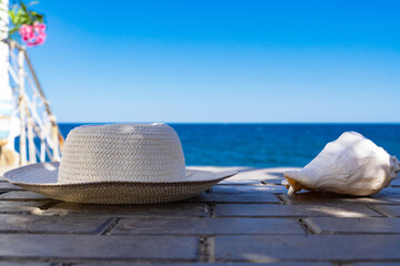 seashell and hat on the background of the blue sea