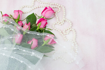 a bouquet of pink roses wrapped in a veil