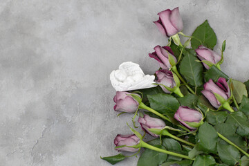 on a gray concrete background a bouquet of pink roses and a figurine of a sleeping angel