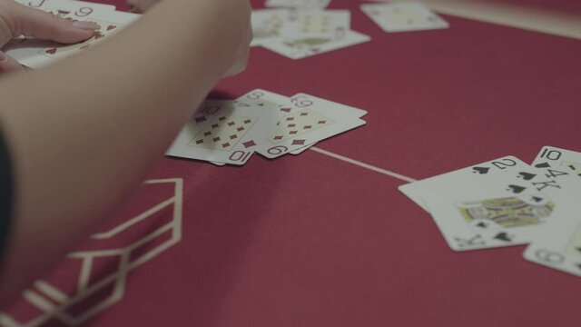 Close view of female hands deal pocker cards on table during a game