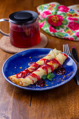 Pancake breakfast for tea. Homemade pancakes with berry jam and honey on wood background. Delicious, healthy, tasty food. Holidays, recipe concept.