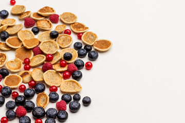 Cereal pancakes and berries on white background.