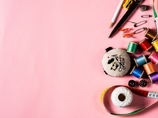 Aerial view of sewing stuff on pink background with copy space