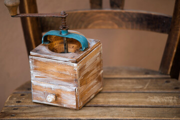 Old wooden coffee grinder on a wooden chair