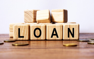 wooden cubes and LOAN, coins, the concept of taxation, increase taxes and fees