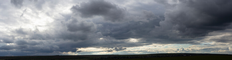 Obraz premium Landscape at sunset. Tragic gloomy sky. The village in the Budjak steppe. The terrain in southern Europe. Panorama.