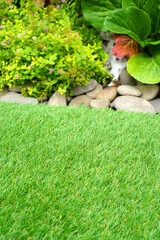 Soft artificial grass in the yard. Comfort at home. Vertical.