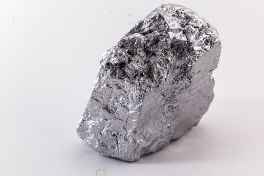 Macro shot of nickel metal ore piece isolated on a white background. Closeup photo of surprising shiny rough mineral, chrome stone, used in industry