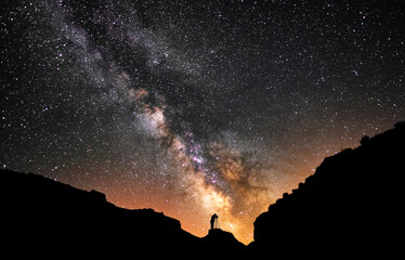 Fototapeta na wymiar Beautiful starry night, photographrs silhouette stands on hill and shooting Milky Way galaxy. Astronomical photgraphy.