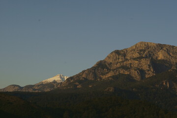 Naklejka premium View of the mountain peaks covered with snow in sunrise